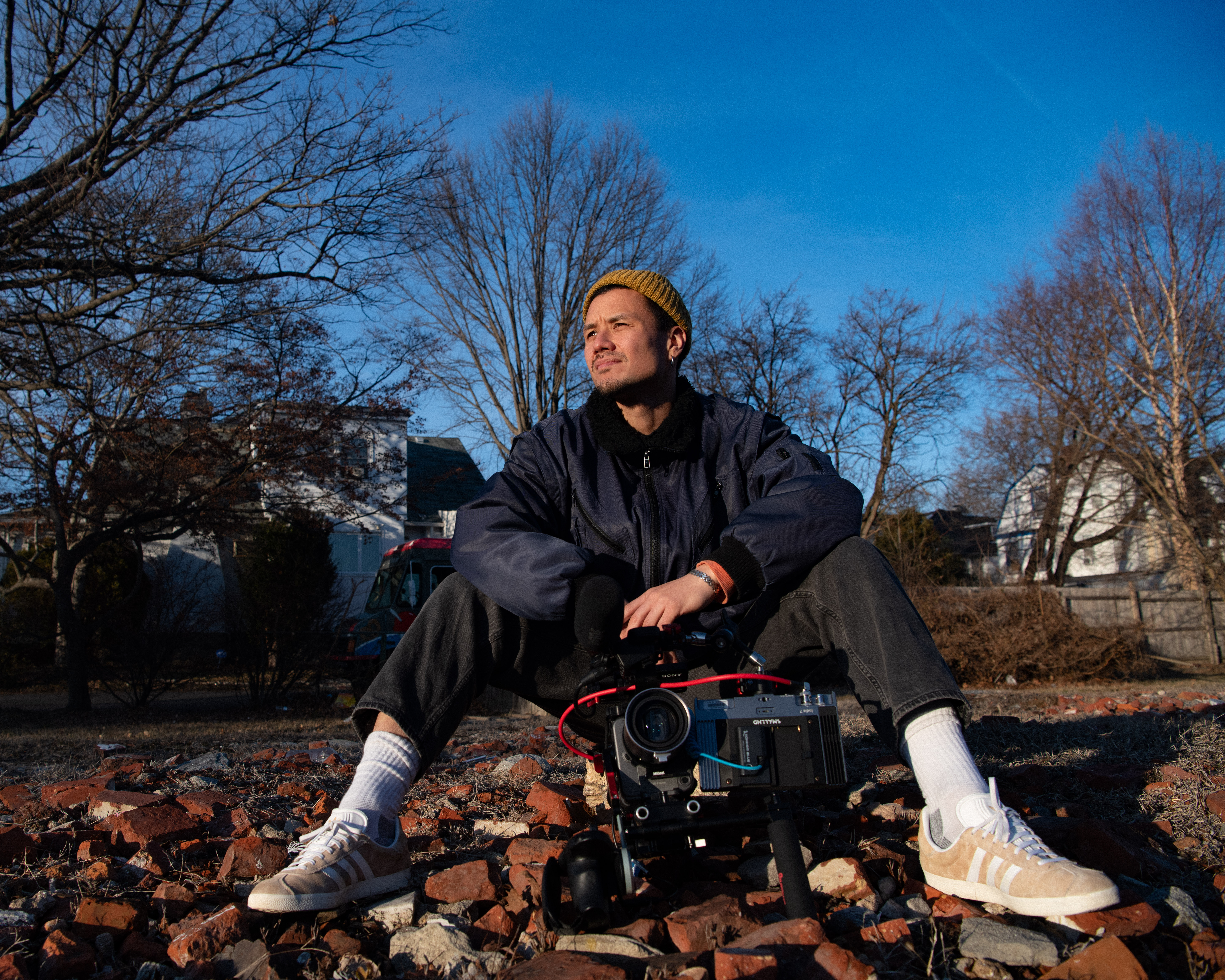 Aidan Un with camera sitting in nature