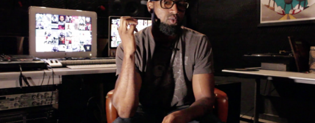 A young music producer sits in a recording studio