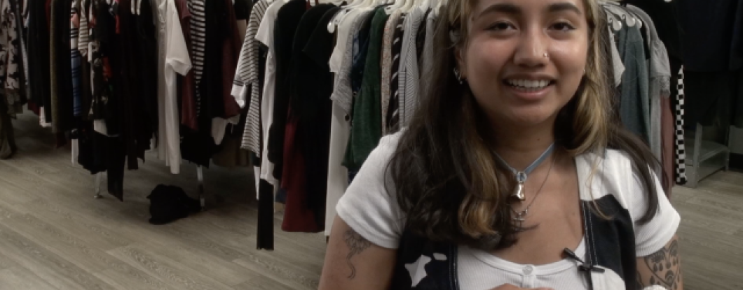 A young woman being interviewed in a clothing store