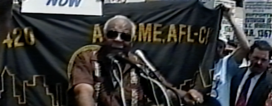 A man speaking at a rally for unemployment benefits