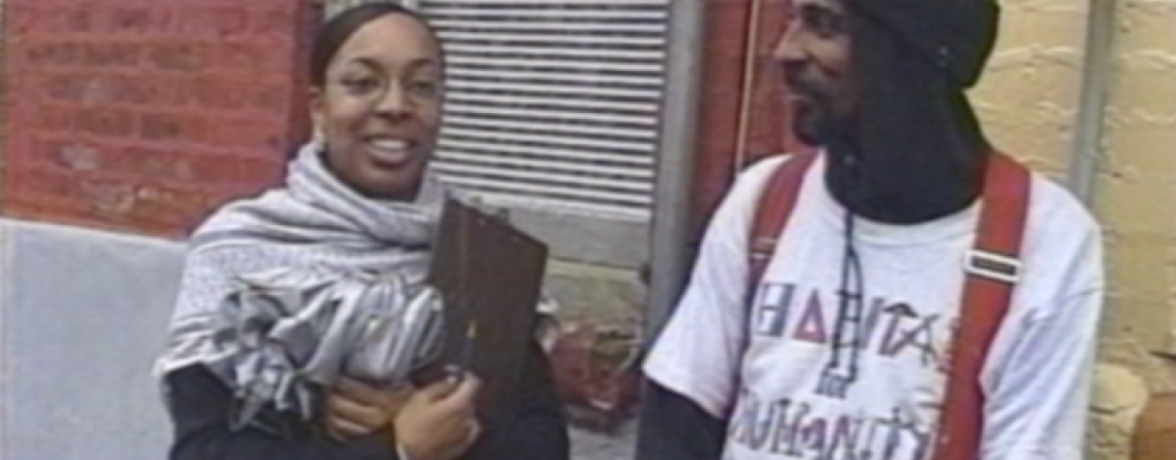 Two Habitat for Humanity employees standing outside a row home