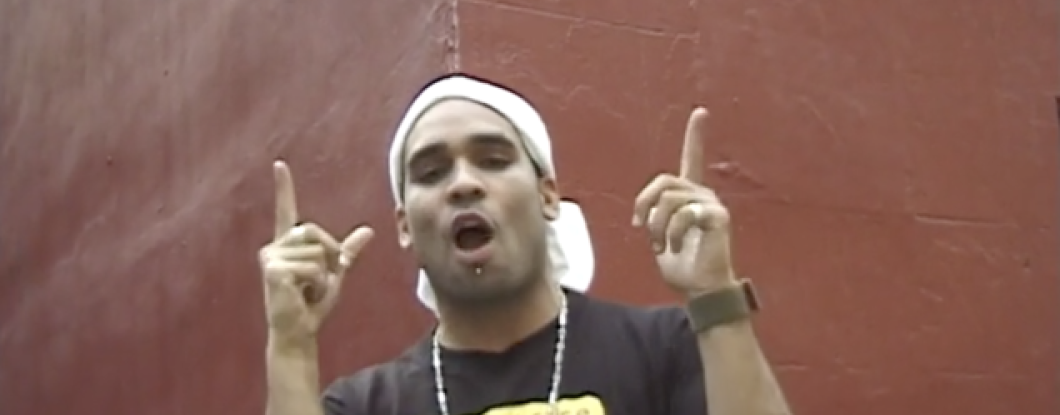 man with a shirt that says 'too little justice' and pointing fingers up