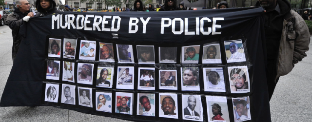 Two people holding a banner showing pictures labeled murdered by police