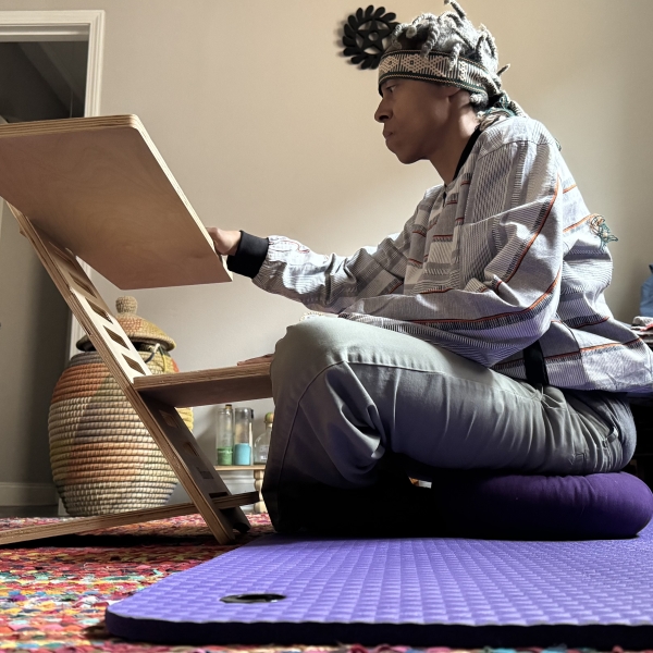 muthi reed sitting on ground by wooden desk