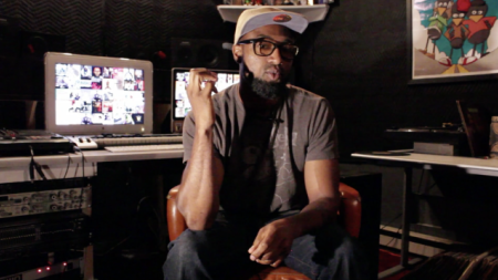 A young music producer sits in a recording studio