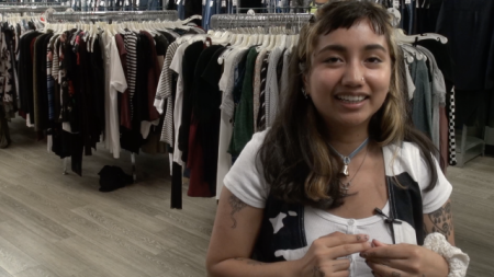 A young woman being interviewed in a clothing store