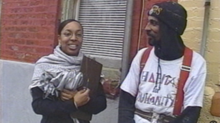 Two Habitat for Humanity employees standing outside a row home