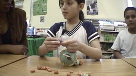 A Girl in a Classroom working on a clay sculpture