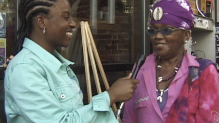 A young woman interviewing a middle aged woman on the street 